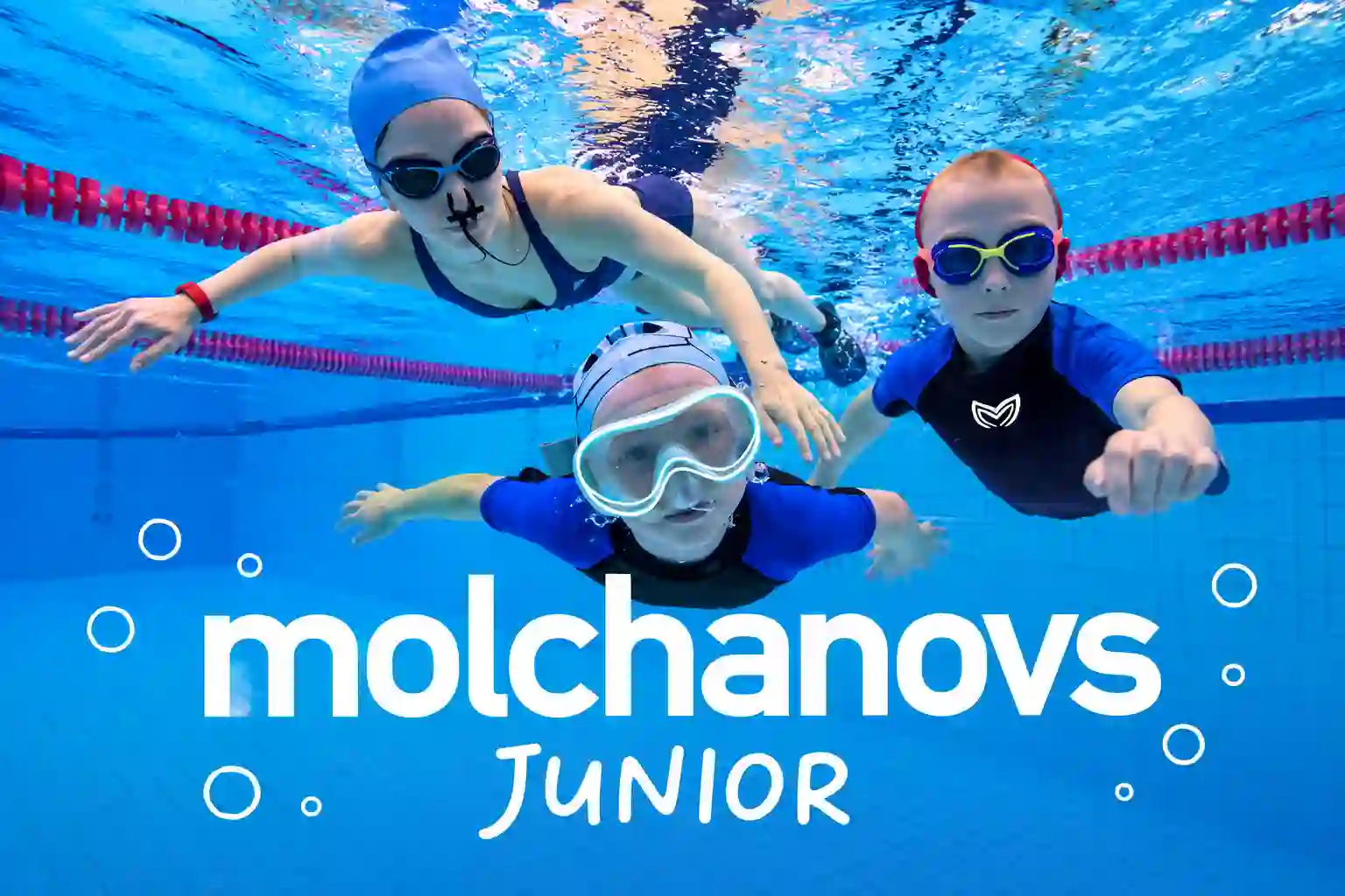Three junior swimmers practicing underwater during a Molchanovs Junior freediving session